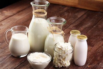 milk products - tasty healthy dairy products on a table on: sour cream in a white bowl, cottage cheese bowl, cream in a a bank and milk jar, glass bottle and in a glass