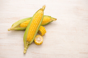 Sweet corns. Fresh corn on cobs on wooden table.