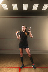 Woman with squash racket, indoor training club