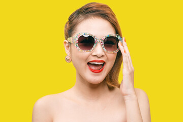 Glamorous asian fashion model posing in vivid colourful clothes and sunglasses. Bright fashion. Optics, eyewear. Studio shot.