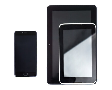 Black cell phone with blank screen and tablet pc computer in metal basket