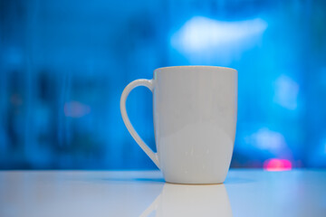 coffee mug on write table with blue background