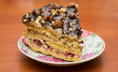 Piece of cake with hazelnuts and chocolate - in a saucer