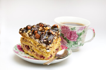 Piece of cake with hazelnuts, teaspoon and cup