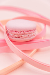 Pink Macaron and paper strips on a light background