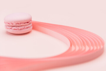 Pink Macaron and paper strips on a light background