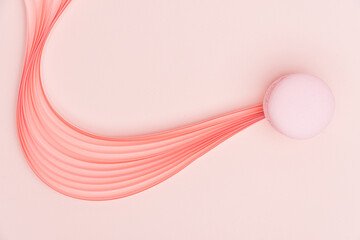 Pink Macaron and paper strips on a light background