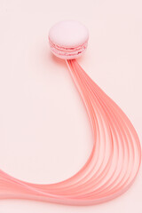 Pink Macaron and paper strips on a light background