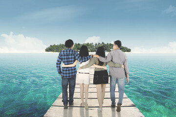 Cheerful friends walking toward island