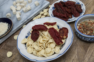 Orecchiette Pasta ingredients preparations with mixed vegetable seasoning, cheese, bay scallops, handmade