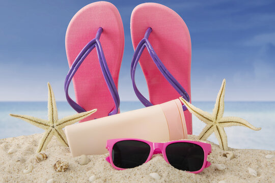 Sandal, sunglasses and sunscreen on beach