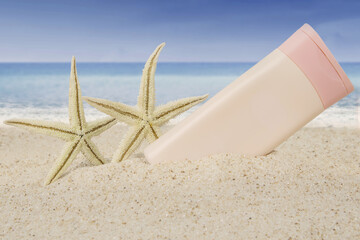 Suncream and starfishes on beach