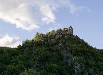 Fototapeta na wymiar Castle on the rock in green woods during summer. Slovakia