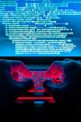 Person's hands coding or hacking on a laptop