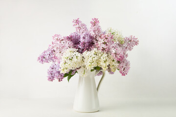 Naklejka na ściany i meble Lilac bouquet in a vase on white background