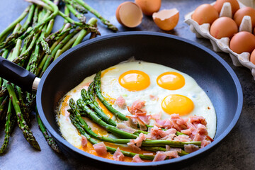 Green asparagus with eggs on an frying pan