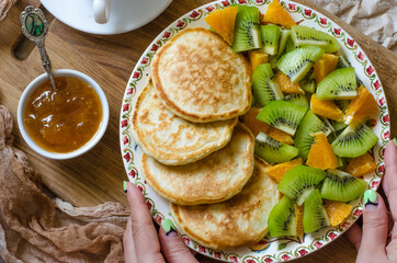 Pancakes with kiwi mandarins and jam for breakfast
