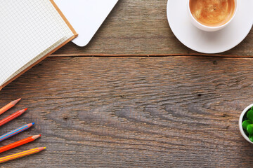 Flat lay open notebook with blank pages next to cup of coffee on wooden table