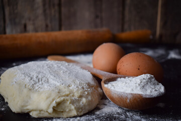 Fototapeta na wymiar flour and bakery ingredients on black background