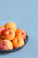 Apricots in a bowl on wooden background. Copy space.