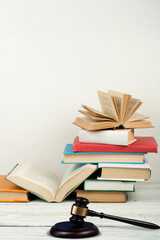 Law concept open book with wooden judges gavel on table in a courtroom or law enforcement office, white background. Copy space for text.