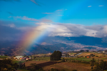 Green meadows and rainbow. View from slope of volcano of Irazu to the valley. Costa Rica