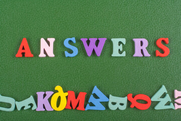 ANSWERS word on green background composed from colorful abc alphabet block wooden letters, copy space for ad text. Learning english concept.