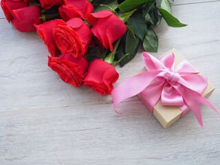 Valentine's setting with bouquet of red roses and present