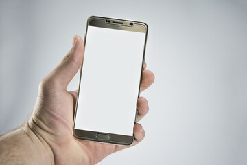 Close-up of a hand holding a phone. Modern smartphone. Isolated on white background. Showing the front of the phone. Blank screen for mockup.