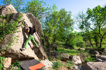 Climber is bouldering outdoors.