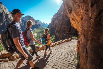 Group of hikers friends walking down the stairs and enjoying view of Zion National Park, USA