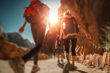 Hikers with backpacks walk on the trail in canyon of Zion National Park, USA. Blurred edges with tilt shift effect © Dudarev Mikhail