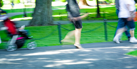 Abstract of people walking in the park with intentional motion blur. Location: Boston Common on a sunny afternoon. Copy space
