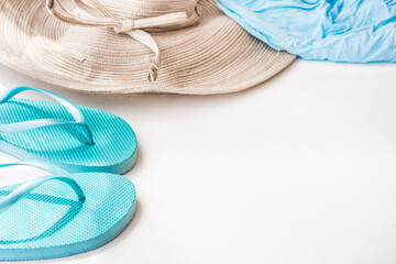 Blue flip flops straw hat beach wrap on white background, summer vacation, seaside, clean minimalist styled image, copyspace, female