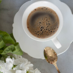 Morning coffee in a beautiful white cup with white flower