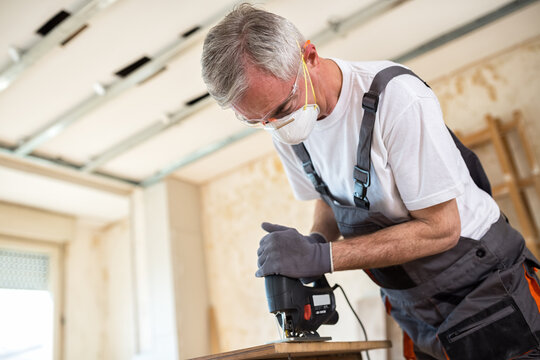 Carpenter working with wood plank at workshop