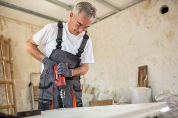 Carpenter used drills  in reparation of old doors