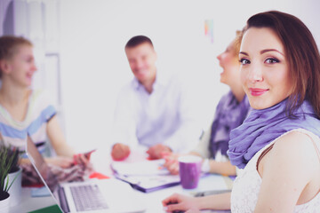 Obraz premium Portrait of attractive female designer sitting on desk in office