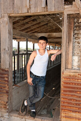 Fototapeta na wymiar Boy standing at old barn