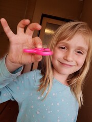 little girl with fidget finger spinner stress, anxiety relief toy