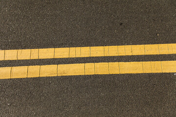 Yellow Line Markings on Asphalt Abstract