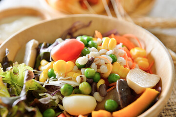 bowl of salad with vegetables  on wooden table