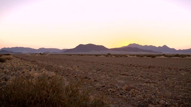 Plane landing on airstrip in late afternoon