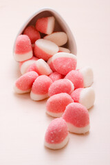 Pink jellies or marshmallows with sugar on table