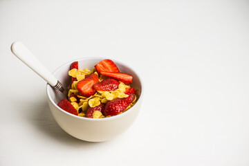 Corn flakes with fresh strawberry in bowl on the rustic background. Shallow depth of field.