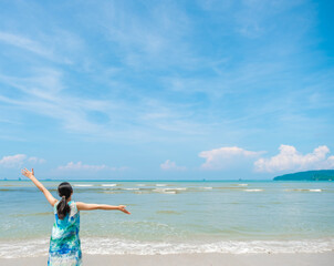 Asian Young woman in her 20s with arms apart on sand beach at Krabi, Thailand