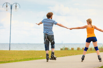 Young couple on roller skates riding outdoors