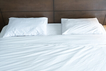 Fototapeta na wymiar white pillow on the white bed in the bedroom