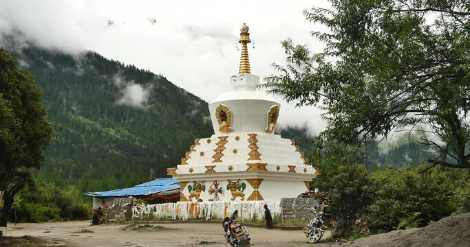 4k tibet people walking around buddhist white stupa in village,cloud cover mountain.