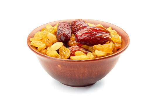 Bowl of raisins and date fruits on white